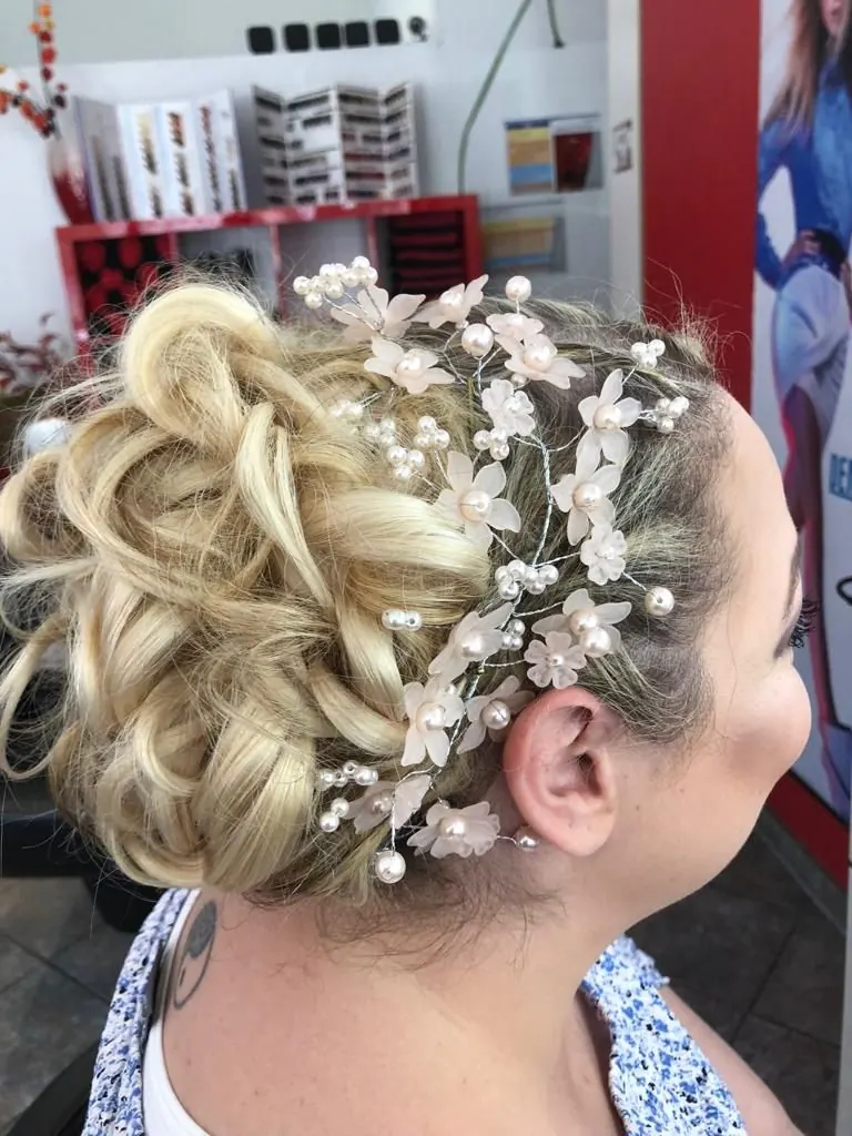 Brautfrisur mit Blütenschmuck und Perlen
